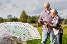 rolnik i rolniczka na polu, po lewej wachlarz polskich banknotów