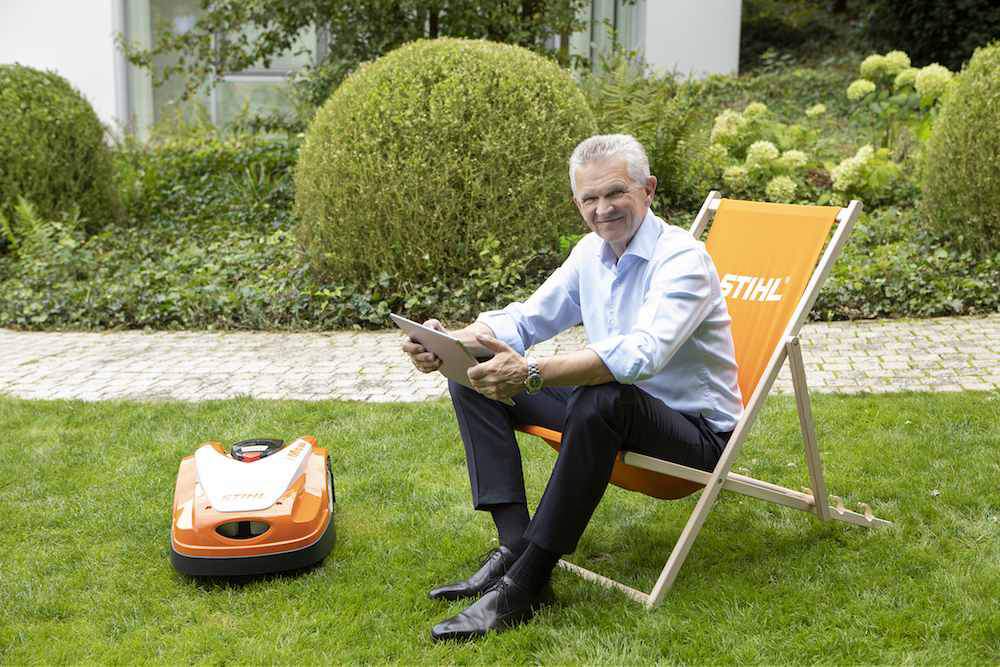 Prezes firmy prezentuje automatyczna kosiarkę w barwach Stihl.