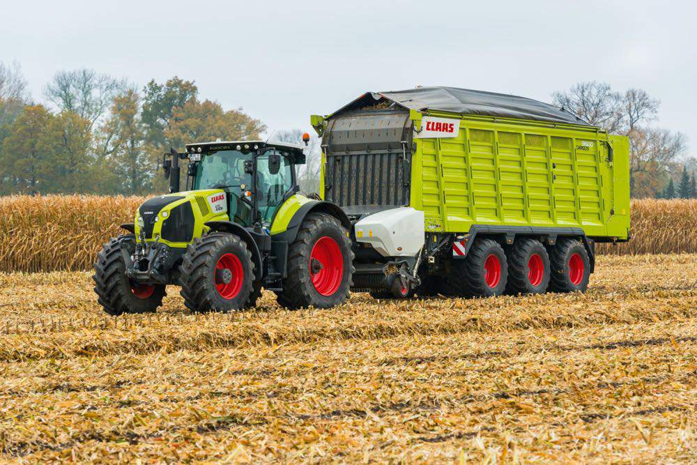 Nowa przyczepa objętościowa Claas Cargos z systemem TIM Speed Control, nowymi kurtynami do zabezpieczania ładunku, ogumieniem i adapterem rozrzucającym zieloną masę.