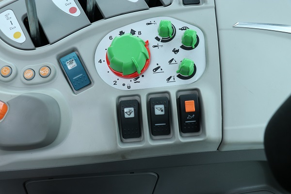 Trzy przyciski na prawej konsoli do obsługi fabrycznie zamontowanego ładowacza, tj. aktywacja joysticka, 3. funkcji, amortyzacji wysięgnika
